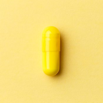 Pharmaceutical,medicine,pills,,tablets,and,capsules,on,colourful,yellow,background.