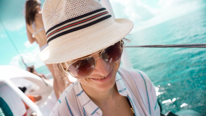 woman wearing a sun hat to protect her shiny hair
