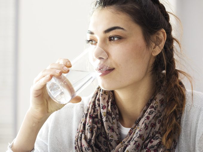 Chronic dry mouth, woman drinking glass of water