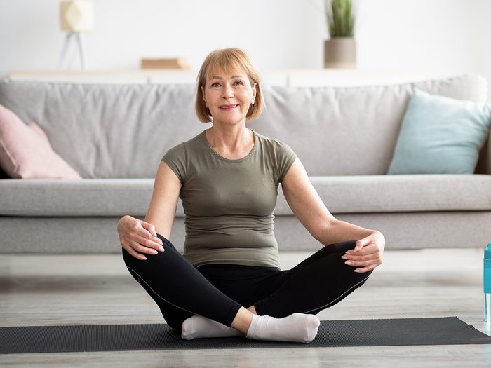 anti-aging yoga poses | Positive,senior,woman,sitting,in,lotus,pose,on,sports,mat,