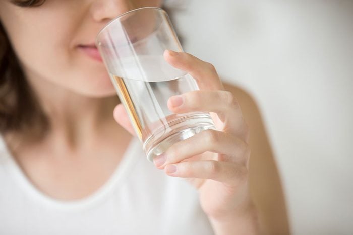 Lactose intolerant woman drinks glass of water