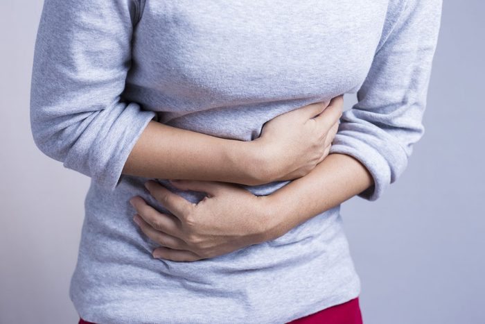 Lactose intolerant woman holds her stomach in pain