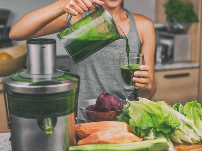 how to juice, woman with a juicing machine making green juice