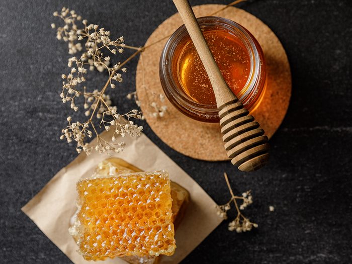 Honey,bee,and,honeycomb,with,honey,dipper,and,dry,flower