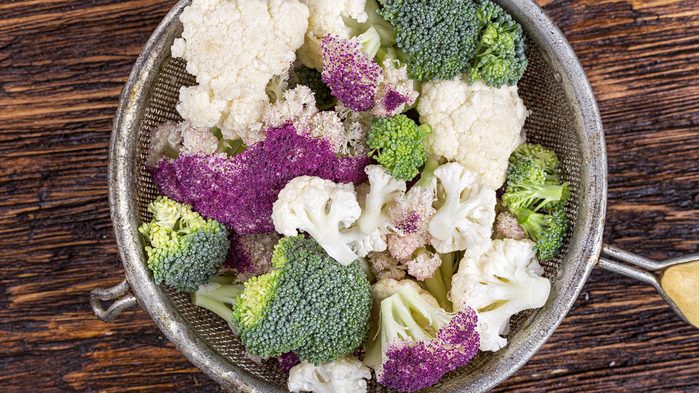 antiaging foods vegetabiles, a sieve filled with broccoli and cauliflower chunks