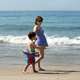 Pregnant woman and her son on the beach