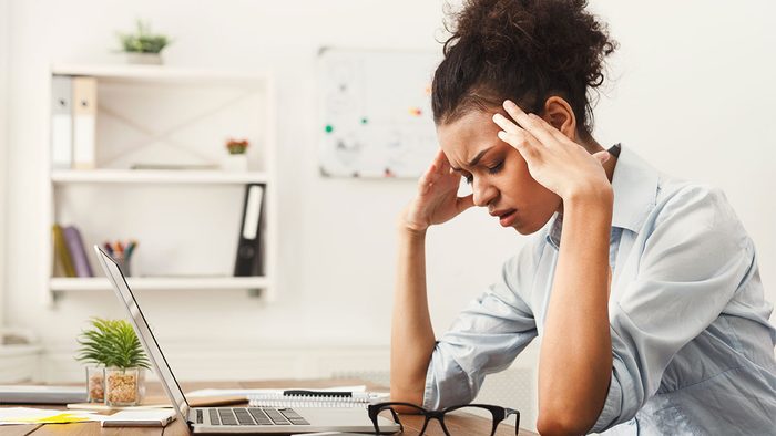 When to call in sick, woman at work desk