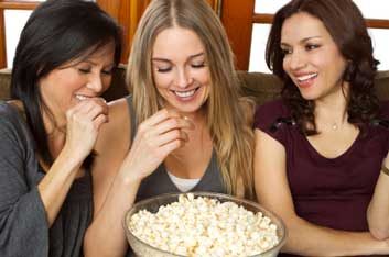 women snacking on popcorn