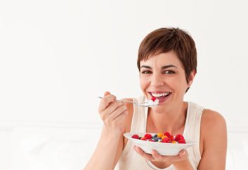 woman eating yogurt and fruit