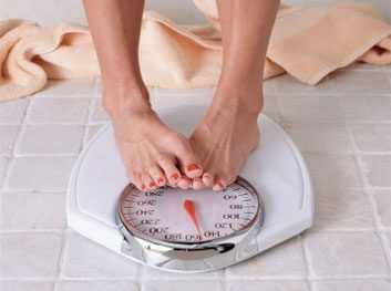 woman on scale weight loss diet