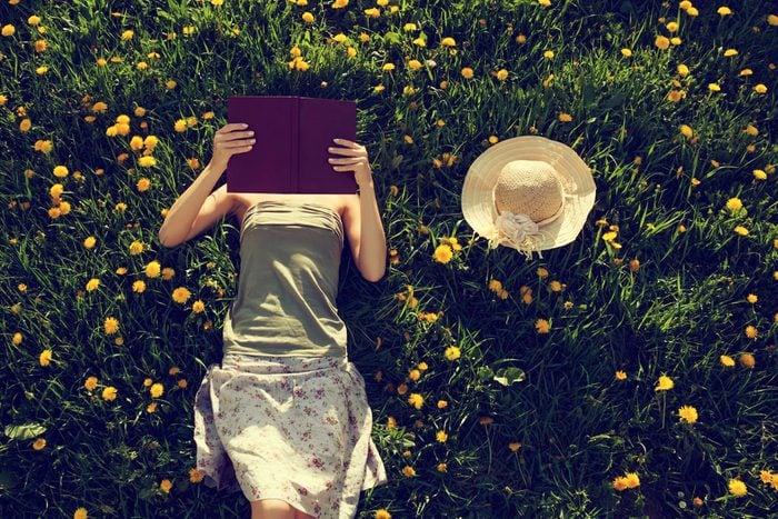 girl lying on grass and reading