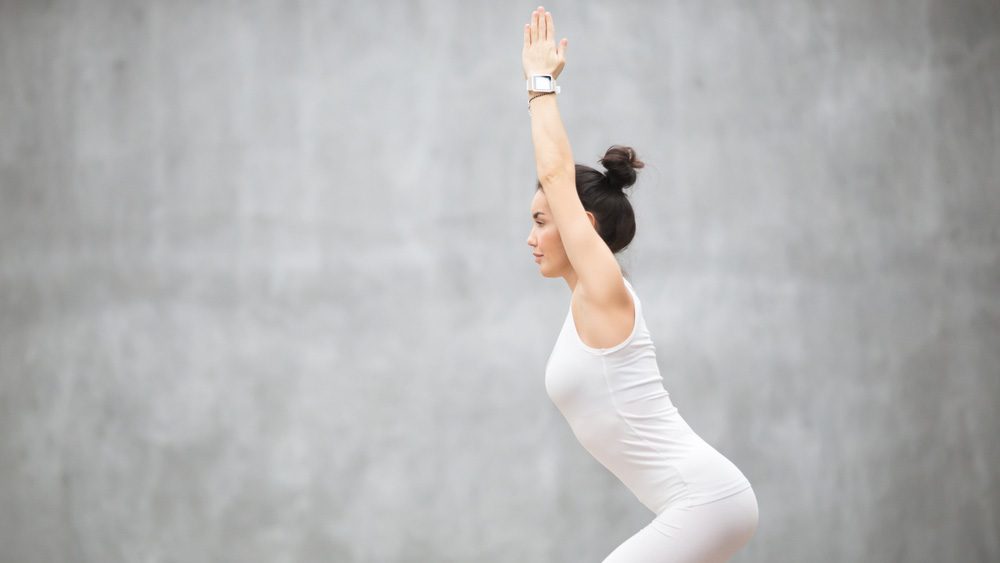 Woman with her hair up in a bun doing yoga