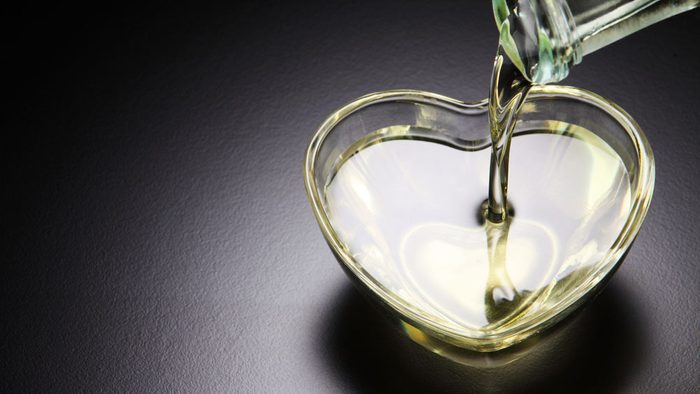 oil is being poured into a pretty heart-shaped bowl
