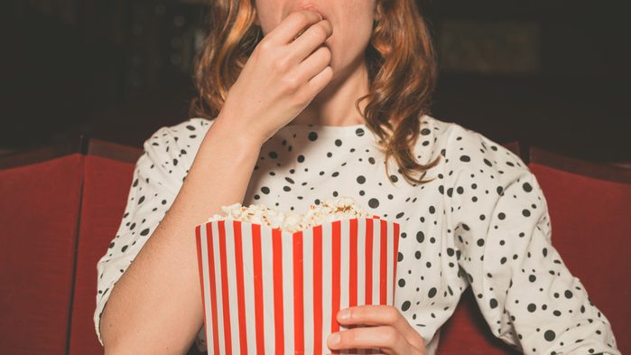 woman eating popcorn at the movies