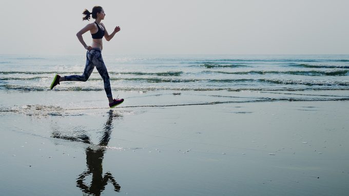 What do those blood pressure numbers mean, woman running on the beach for her cardio exercise