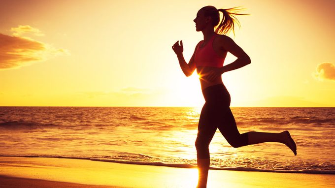 autoimmune diseases and women, a woman is running into the sun set on a beach