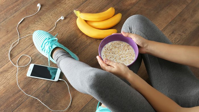 eat after a run, a woman sitting on the floor with some food after a run