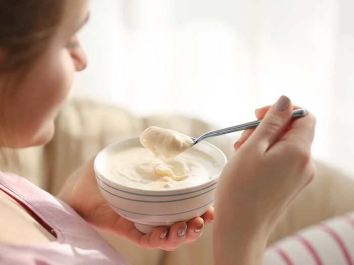 yogurt remedy for UTIs, woman eating yogurt