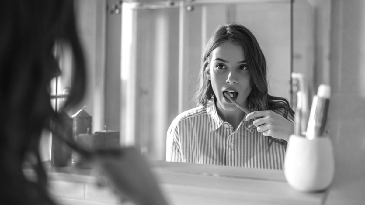 Cut back on sugar, woman brushing her teeth