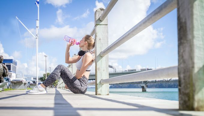 drink water for weight loss, woman drinking water during a run