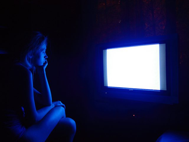 blue light damage similar to sunburn, woman watching tv late at night
