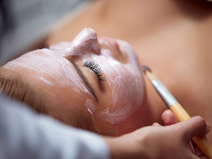 Blackheads, woman lying down for professional facial and having treatment painted on her face