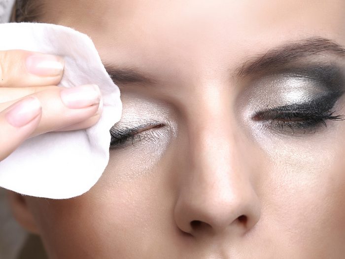 Blackheads, woman removing her eye makeup with a cotton pad
