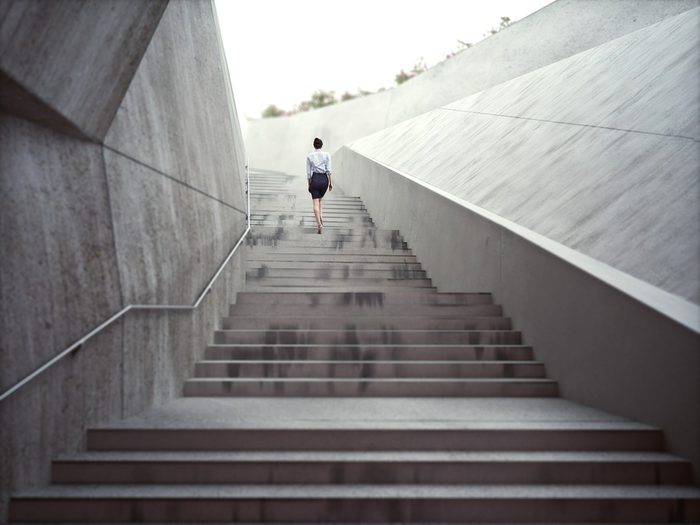 Flat stomach, woman climbing long flight of concrete steps