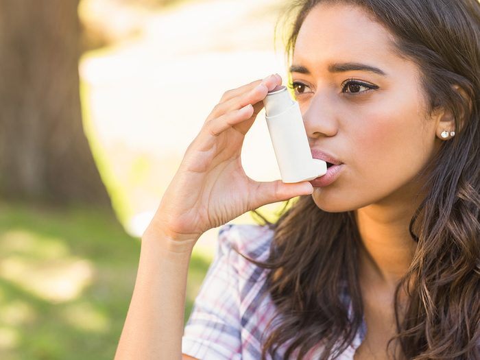 Green tea, young woman with asthma using inhaler