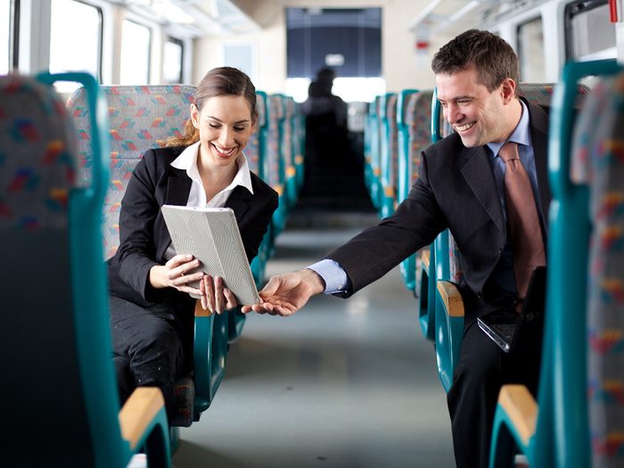 Happiness, man and woman chatting across aisle during train commute
