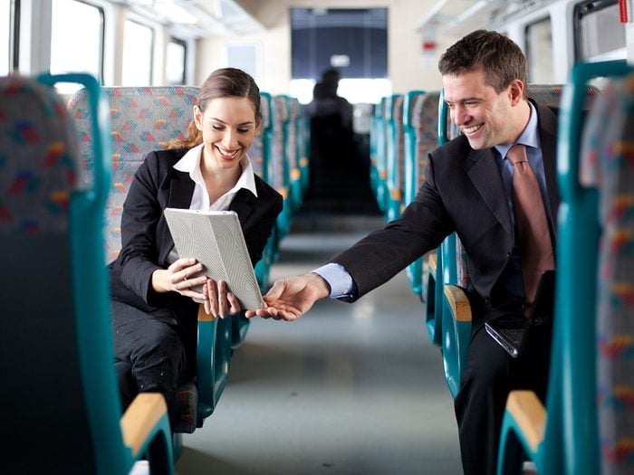 Happiness, man and woman chatting across aisle during train commute