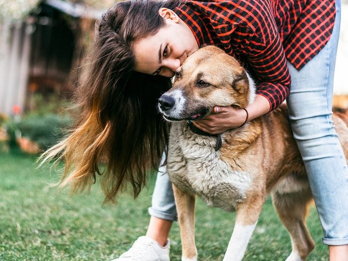 Happiness, young woman hugging a scruffy dog outdoors