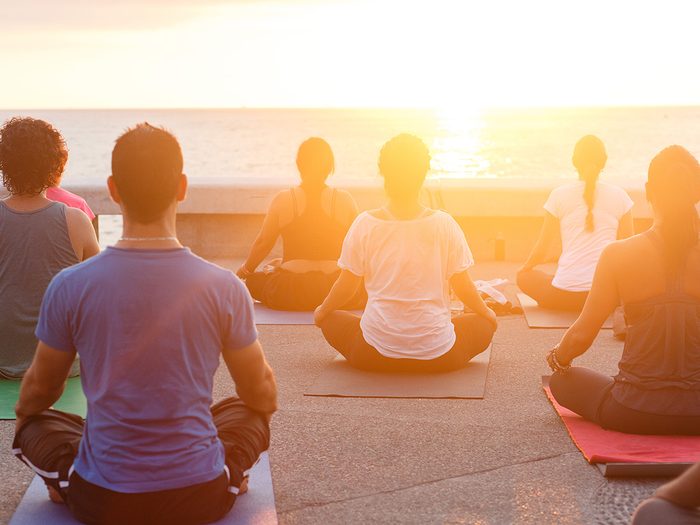 Health trends, sunrise yoga on a pier
