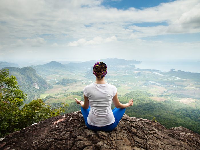 Health trends, woman doing yoga on top of a mountain in Thailand