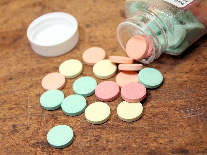 Antacid pills for hearburn spilled out on a wood table