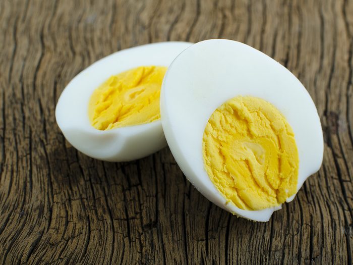 How to eat healthy, hardboiled egg cut in half on a wooden surface