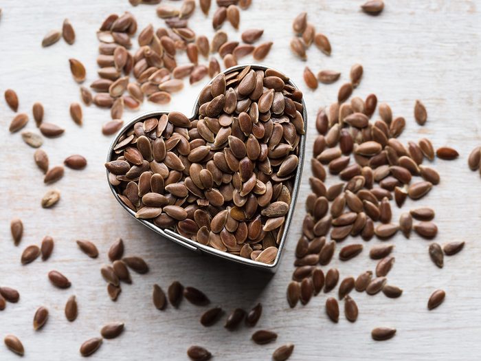 Menopause symptoms, flaxseed spilling out a heart-shaped container