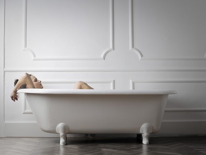 Menopause symptoms, woman takes a bath in a calm white room