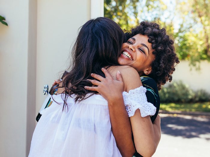 Self love, two woman hug at the entrance to a dinner party