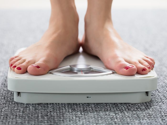 Weight gain, woman's feet on scale