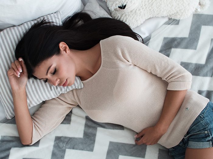 Weight gain, woman with cramps holds her stomach