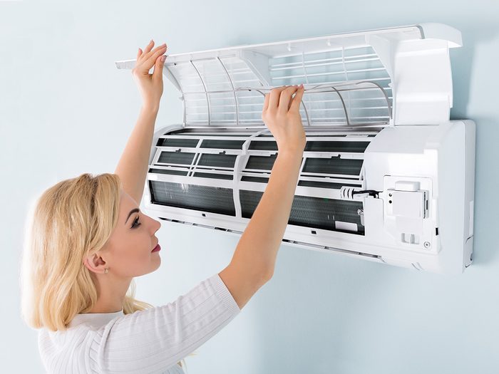 Allergies, woman changing filters for air conditioner