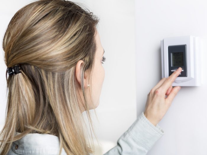 Allergies, woman adjusts thermostat