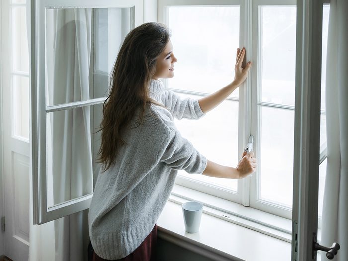 Allergies, woman closing windows of her house
