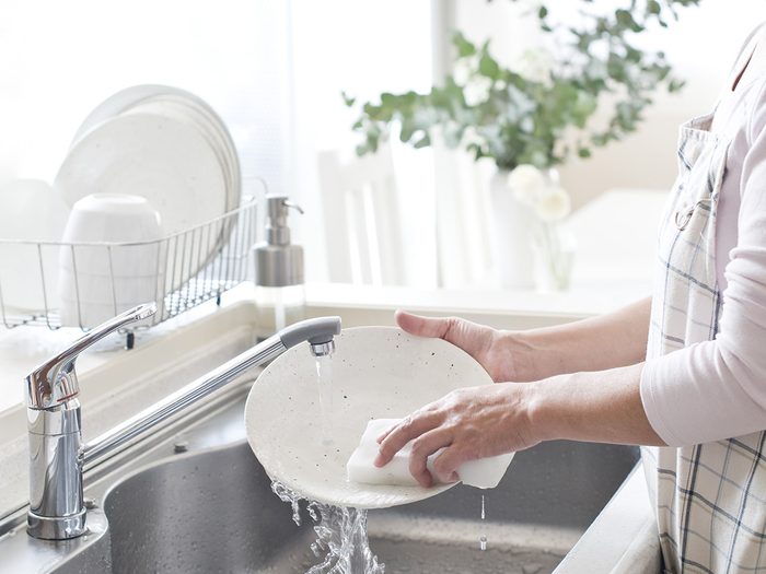 Eczema, woman washes dishes in a bright, airy kitchen