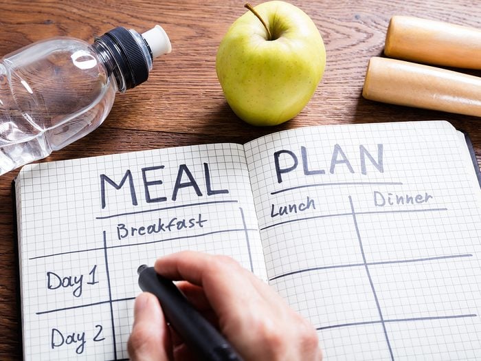 Extreme weight loss, person writes in a meal planning notebook
