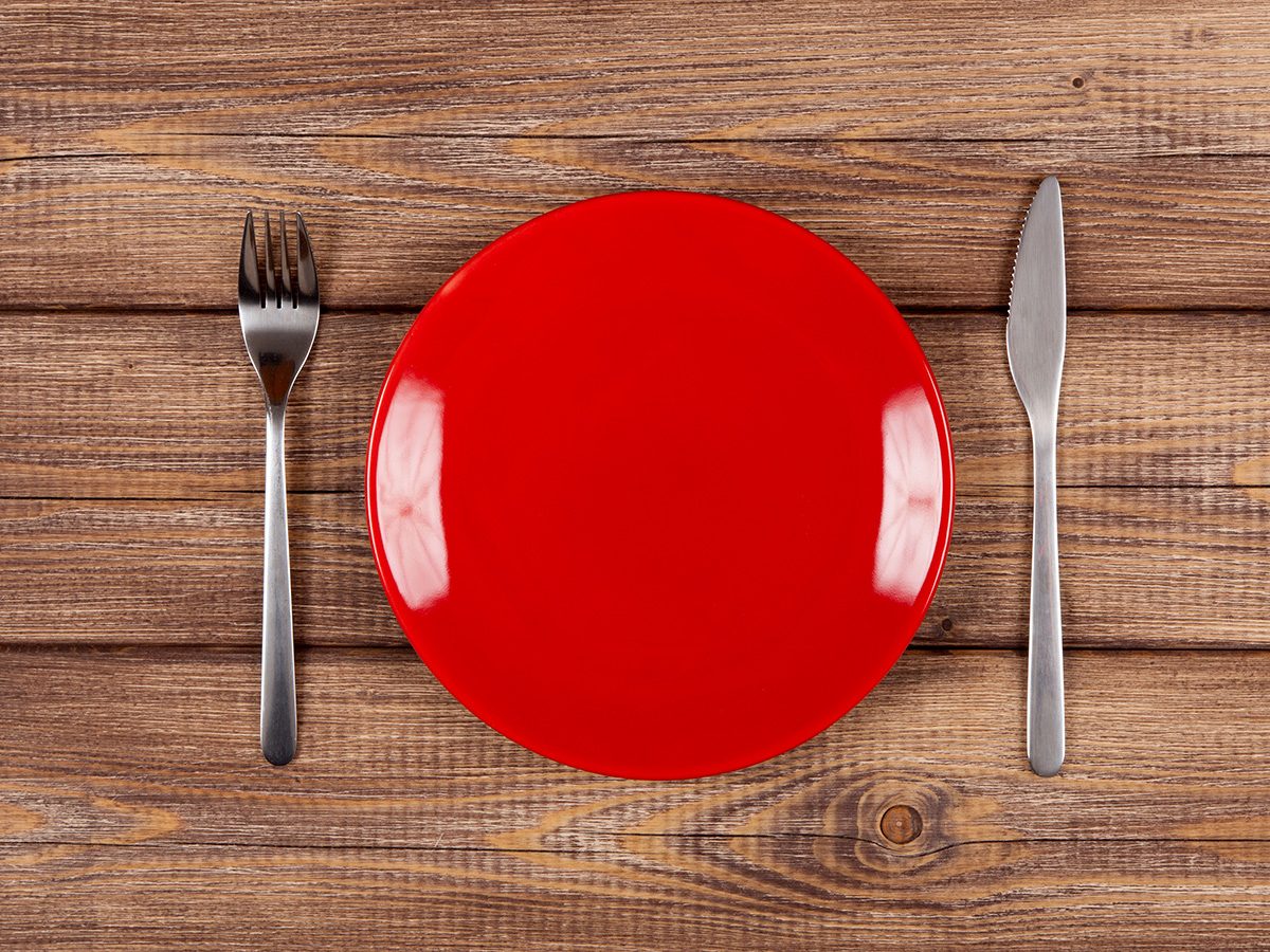 Extreme weight loss, a red plate on a table with a fork and knife