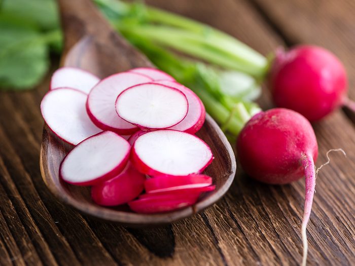 Superfoods, bowl of cut up radishes with full bulbs lying next to it