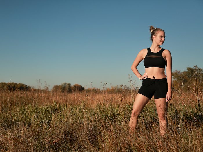 Workout gear, Woman standing in a field wearing black Lunapads sport shorts