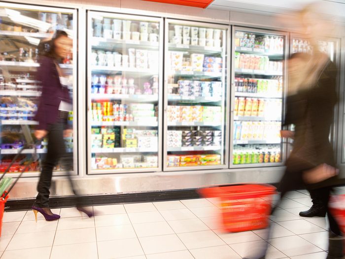 Zero calorie foods, blurry women walking throug the frozen foods aisle at a grocery store